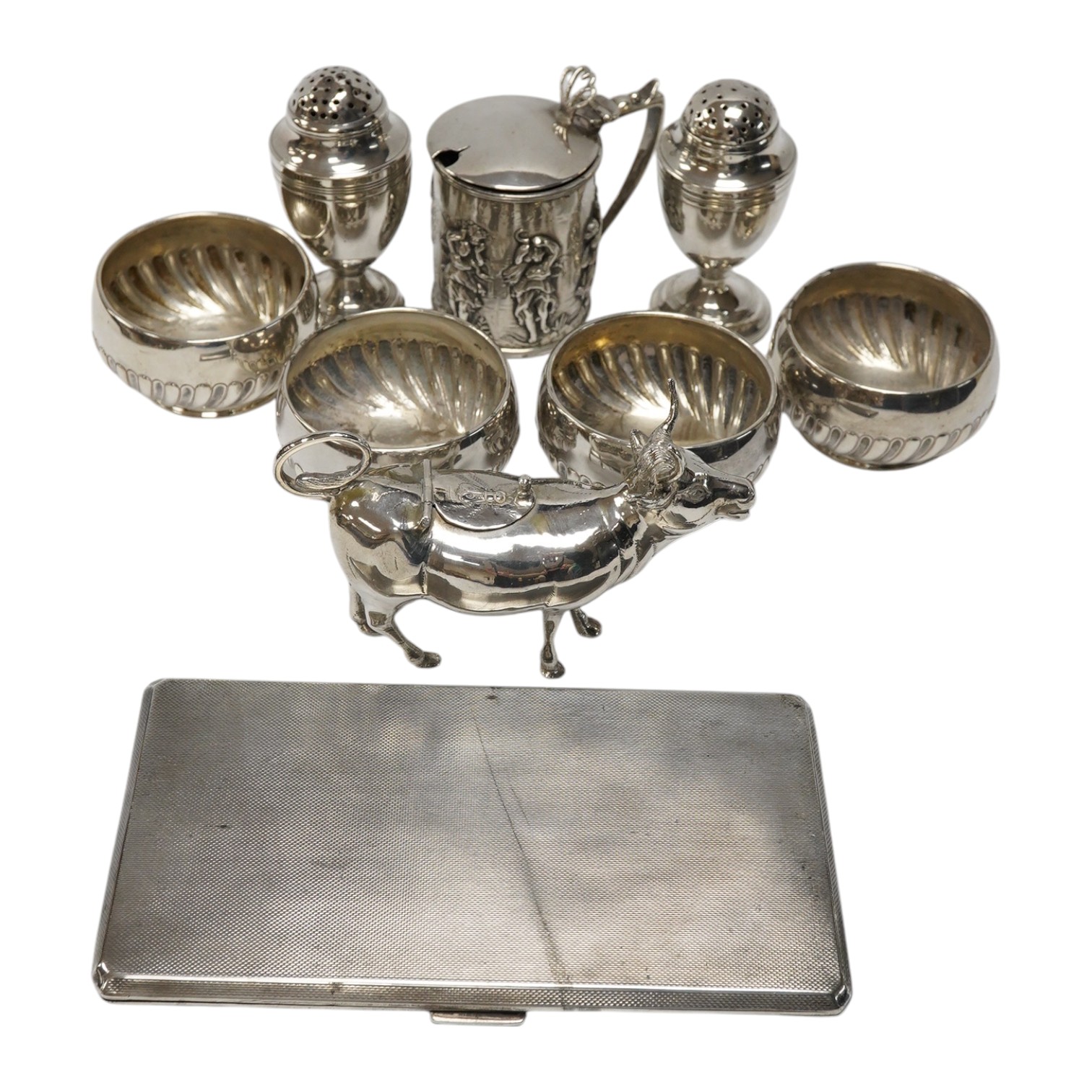 Assorted small silver including a cigarette case, set of four Victorian salts by Thomas Bradbury & Sons, London, 1878, a sterling cow creamer and three condiments. Condition - fair to good